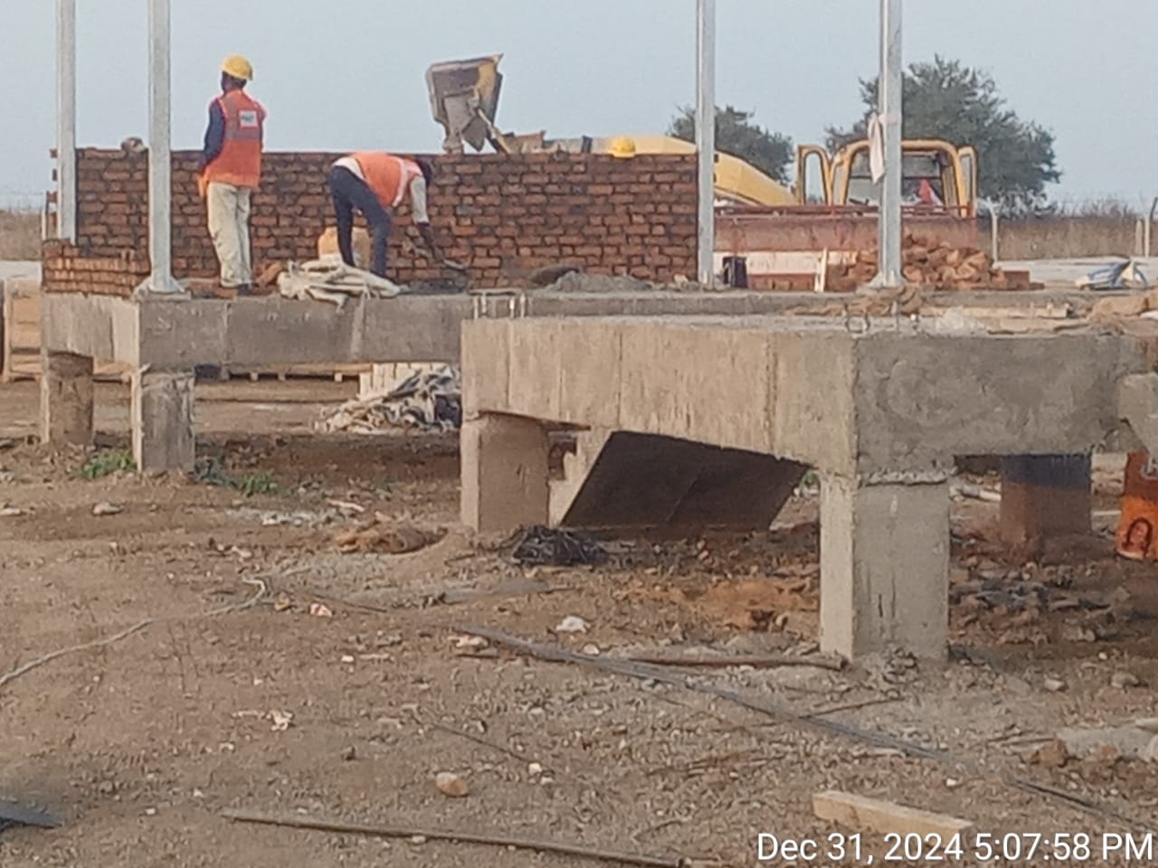 Masons raising brickwork for an equipment room on a cast RCC plinth