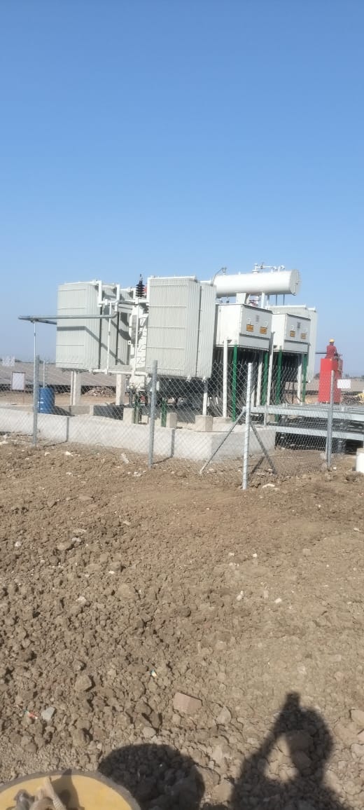 Inverter skids and control equipment behind the plant yard fencing